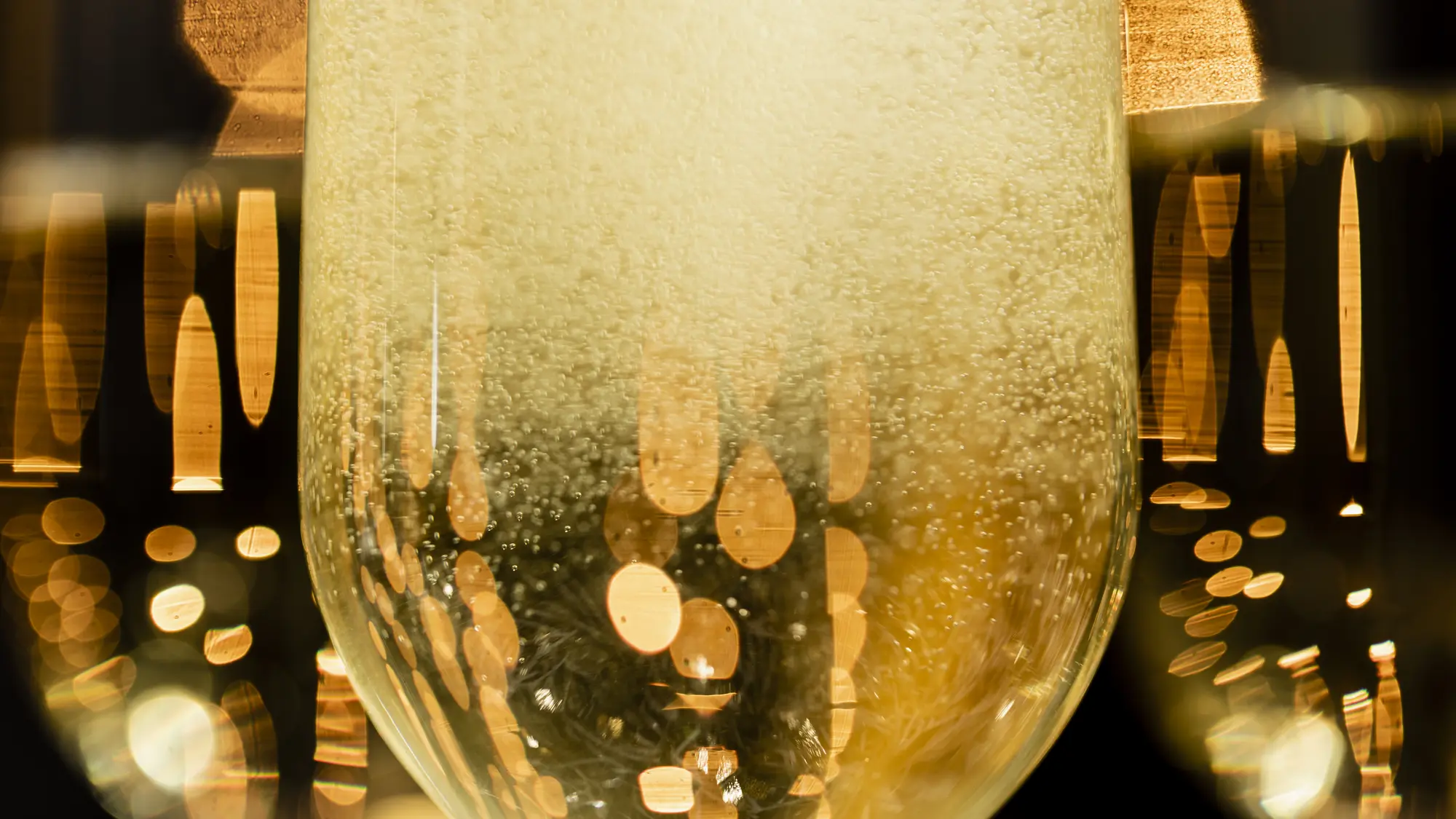Golden sparkling wine bubbles in an elegant glass