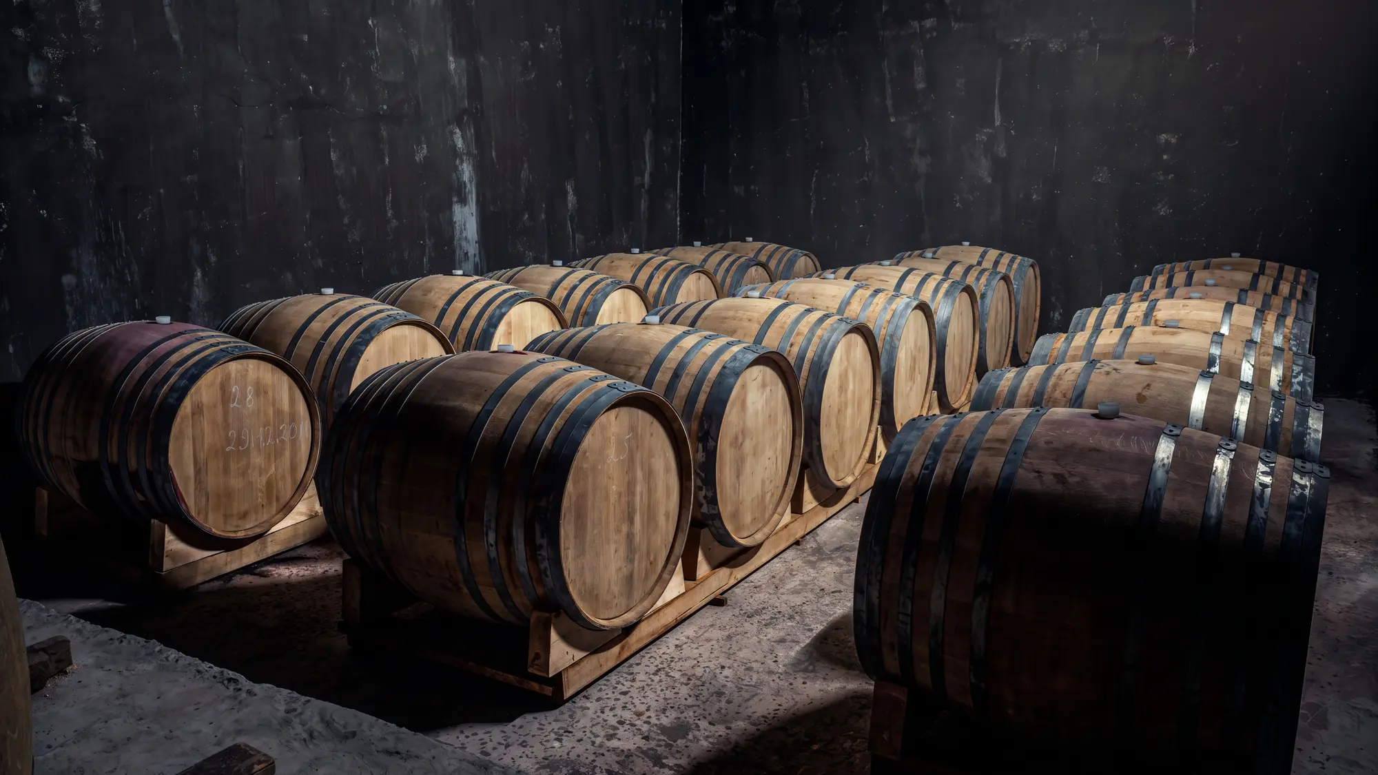 Wine barrels resting in a warm, atmospheric cellar